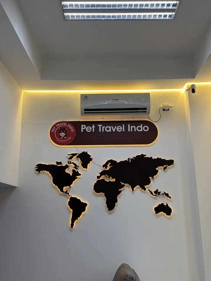 Pet Travel Indo sign and illuminated world map on the office wall
