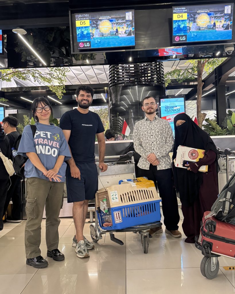Pet Travel Indo team assisting Anna the cat's relocation at Soekarno-Hatta International Airport. The family is standing with airline-approved pet carriers on a trolley, ready for the cat’s international journey from Indonesia to Mongolia. Pet relocation services include flight booking, customs clearance, and ensuring the pet’s safe and comfortable travel abroad.